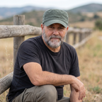 Hombre con gorra de algodón de campo verde junto a valla de madera